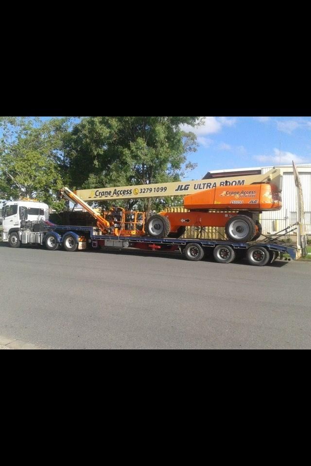 A Tow Truck With a Red Car on the Back — Mick’s Towing Service Pty Ltd in Carrara, QLD