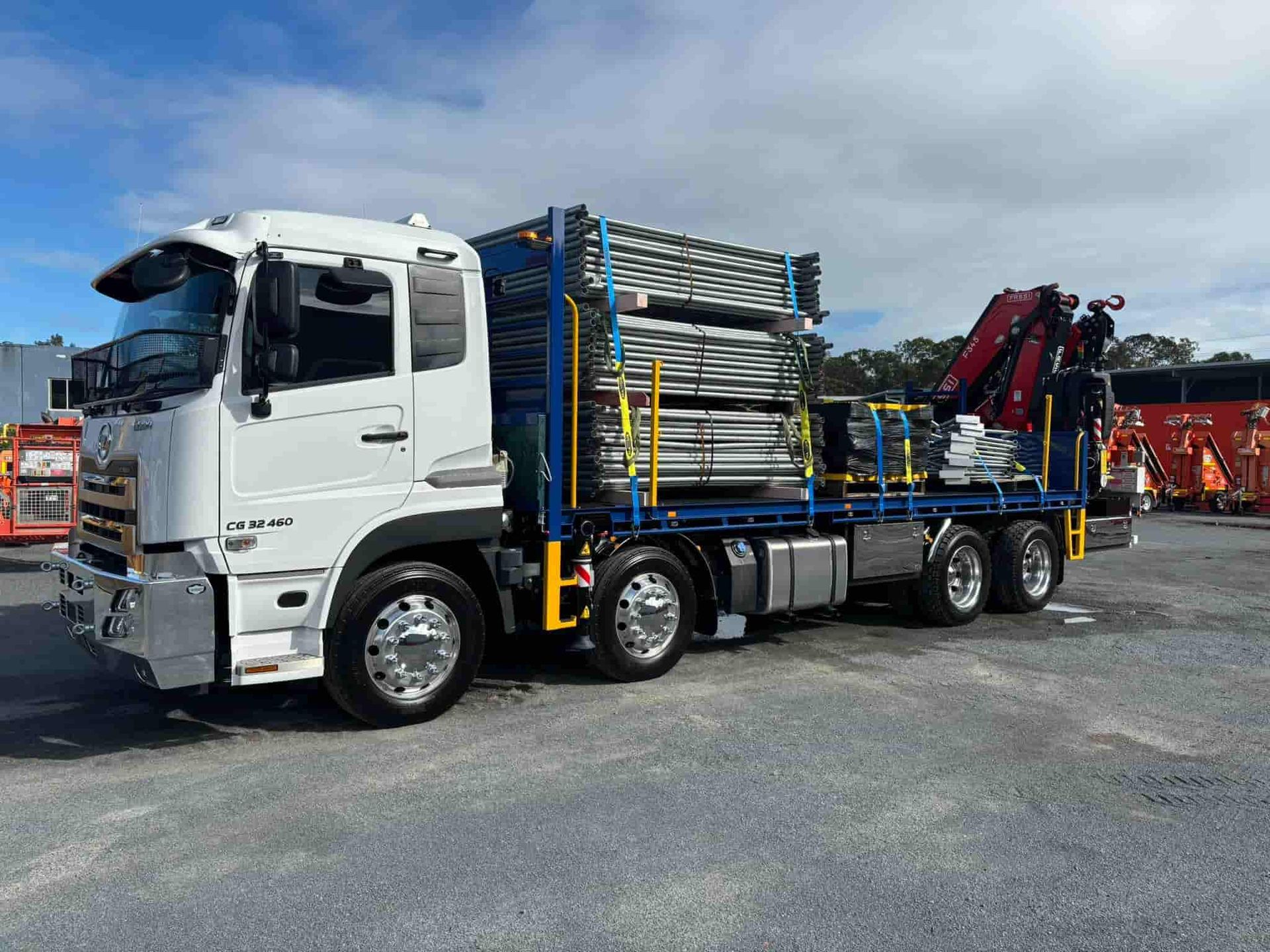 A White Truck With a Crane on the Back is Parked in a Parking Lot — Mick's Towing Service Pty Ltd in Carrara, QLD