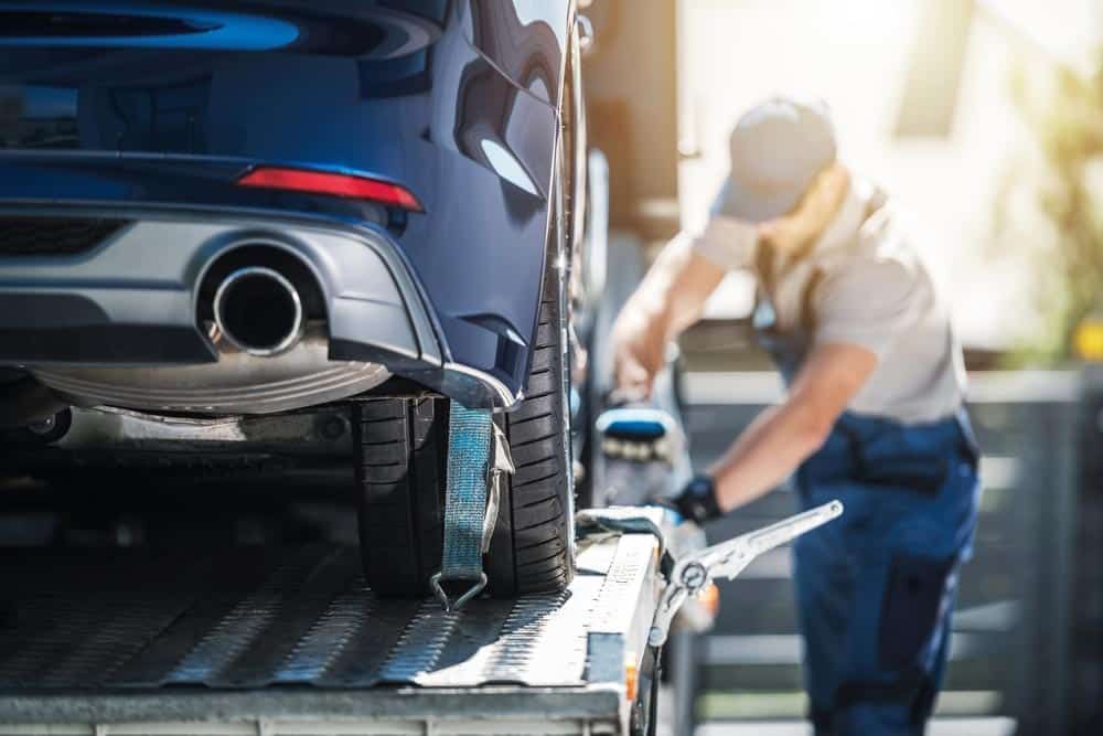 A Man is Towing a Car on a Tow Truck — Mick’s Towing Service Pty Ltd in Carrara, QLD
