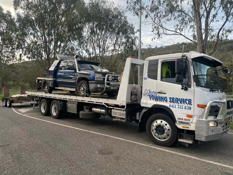 A Tow Truck is Carrying Two Cars on a Trailer — Mick’s Towing Service Pty Ltd in Carrara, QLD