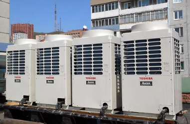 Four white Toshiba air conditioning units on a rooftop.
