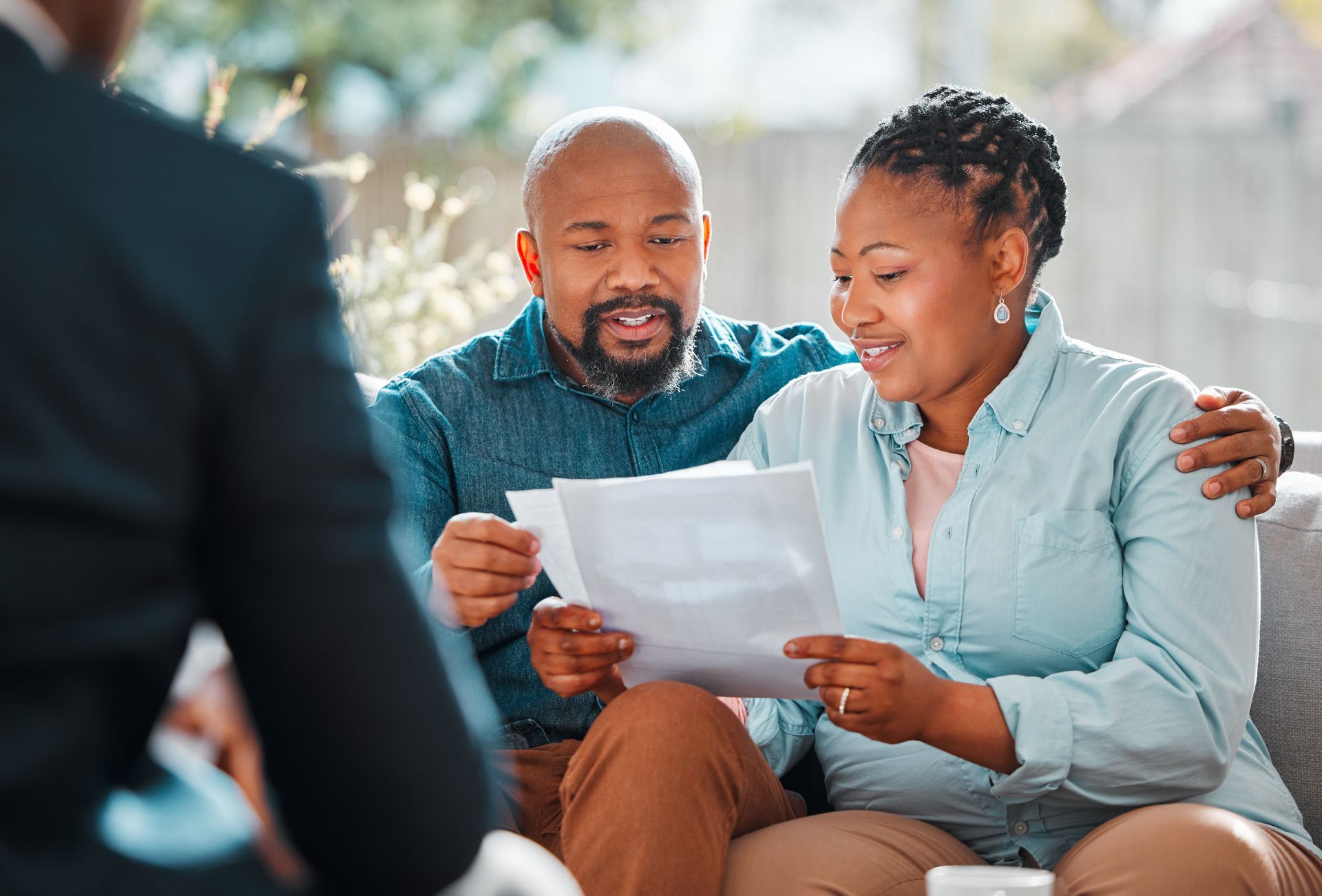 A happy couple reviews a document while consulting with a retirement planning advisor.