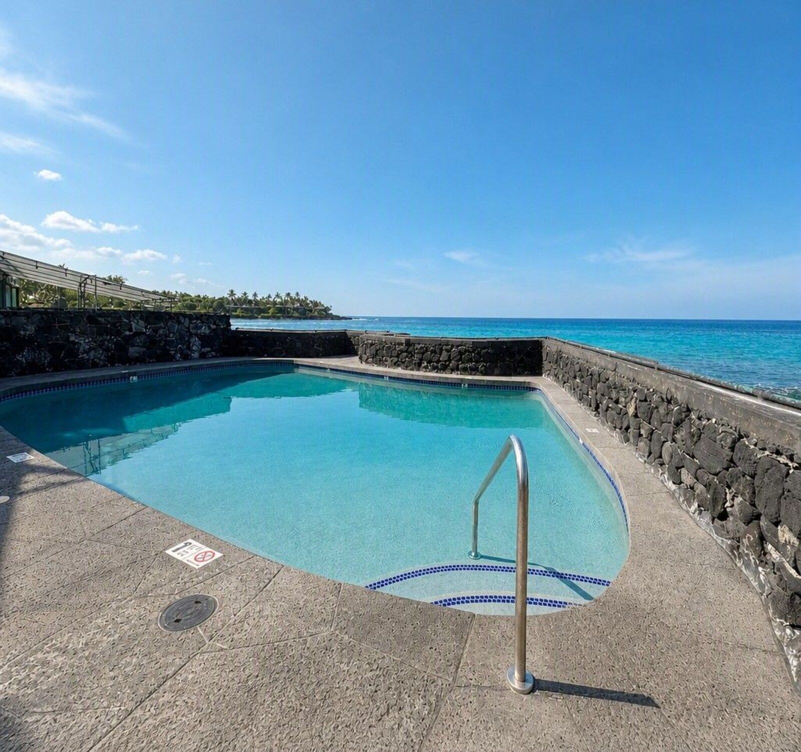 Oceanfront pool at Kona Magic Sands with the ocean beyond the wall