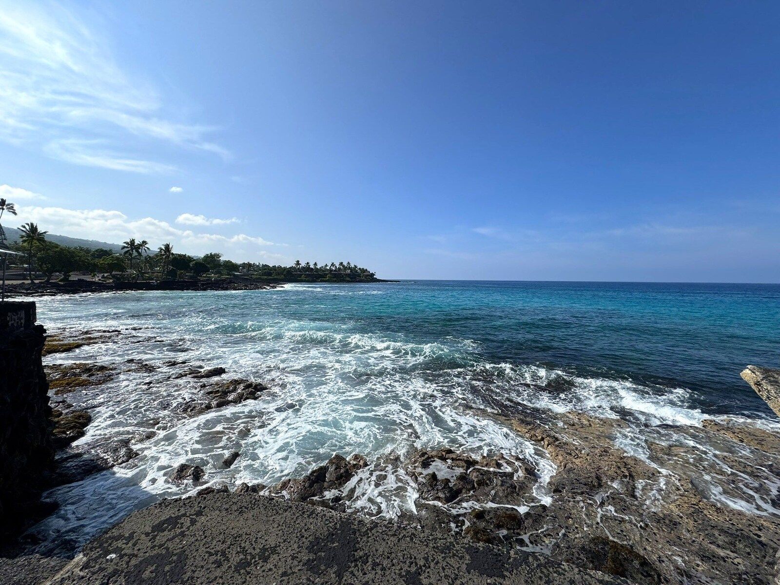 Waves crashing on the rocky shoreline in front of Kona Magic Sands