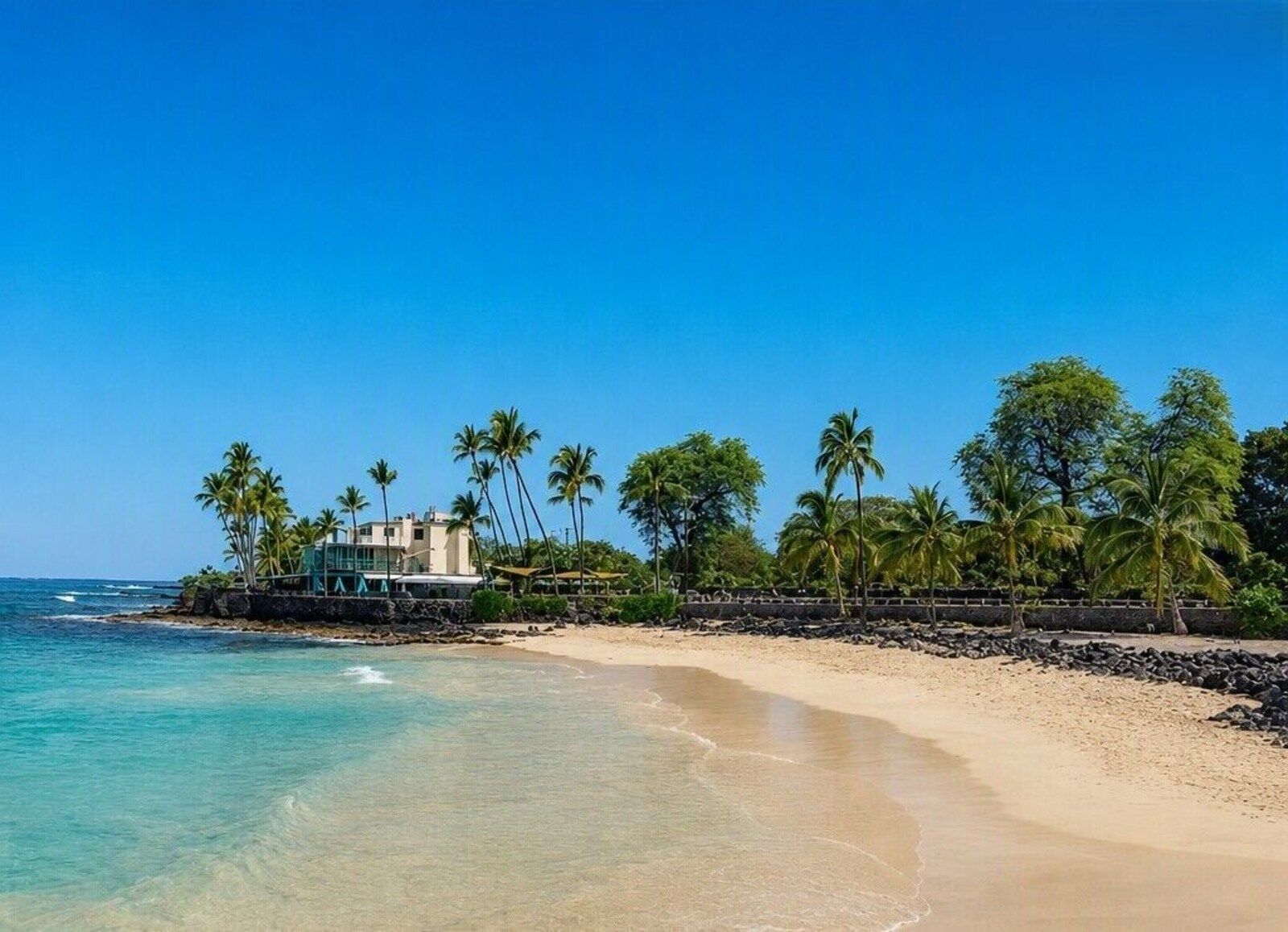 Magic Sands Beach with lava rocks and the Kona Magic Sands building behind