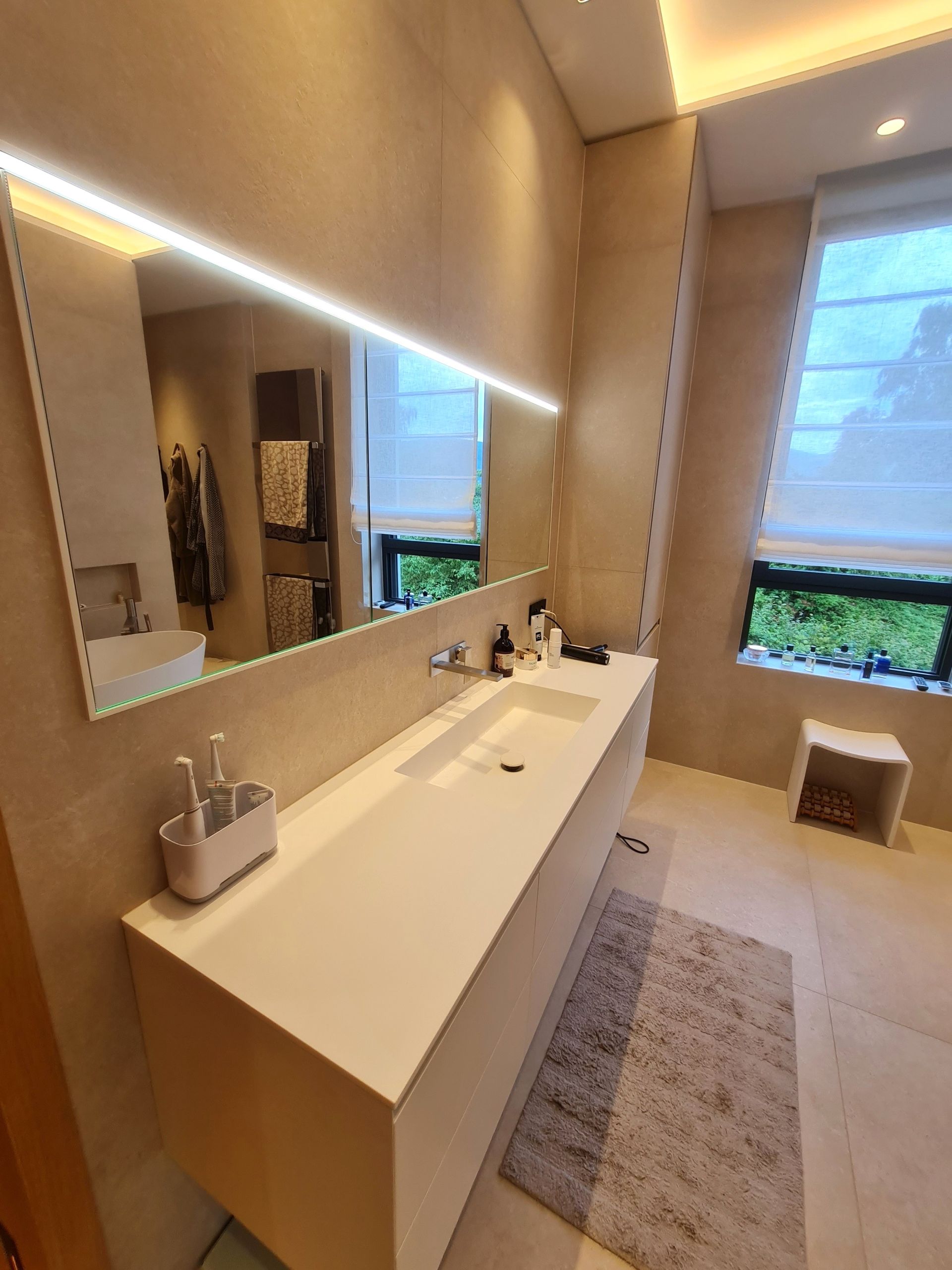 Une salle de bain avec deux lavabos et un grand miroir
