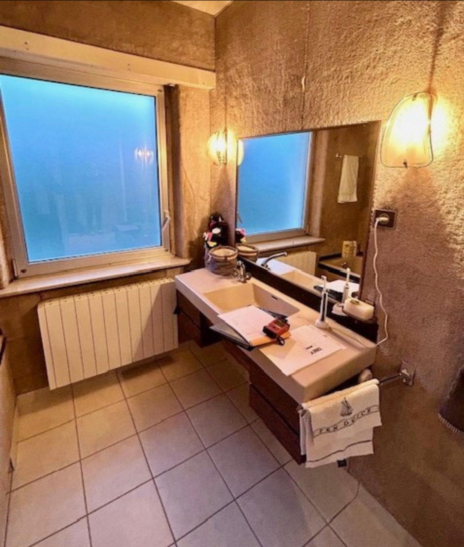 Une salle de bain avec un lavabo, un miroir et une serviette sur laquelle est écrit le roi George