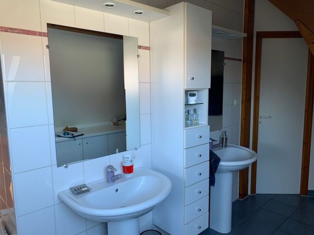 Une salle de bain avec deux lavabos et un miroir