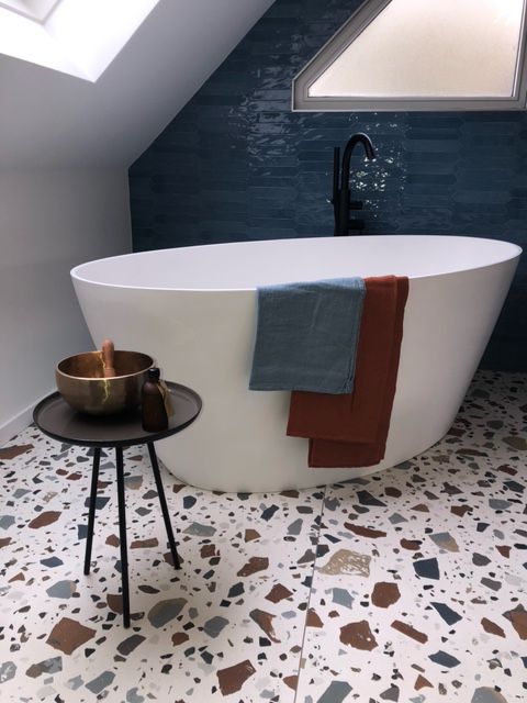 Une salle de bain avec une baignoire et une petite table