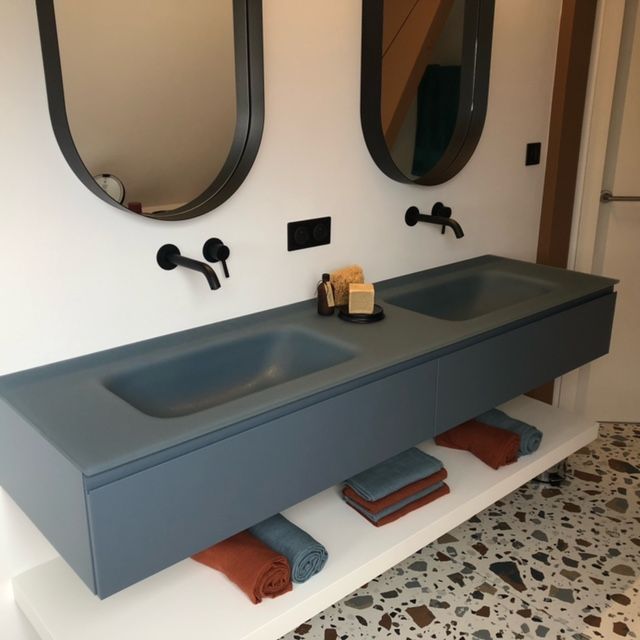 Une salle de bain avec deux lavabos et deux miroirs