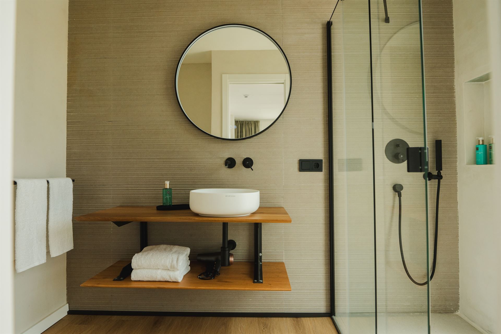 Modern bathroom with sink, mirror, and shower area.