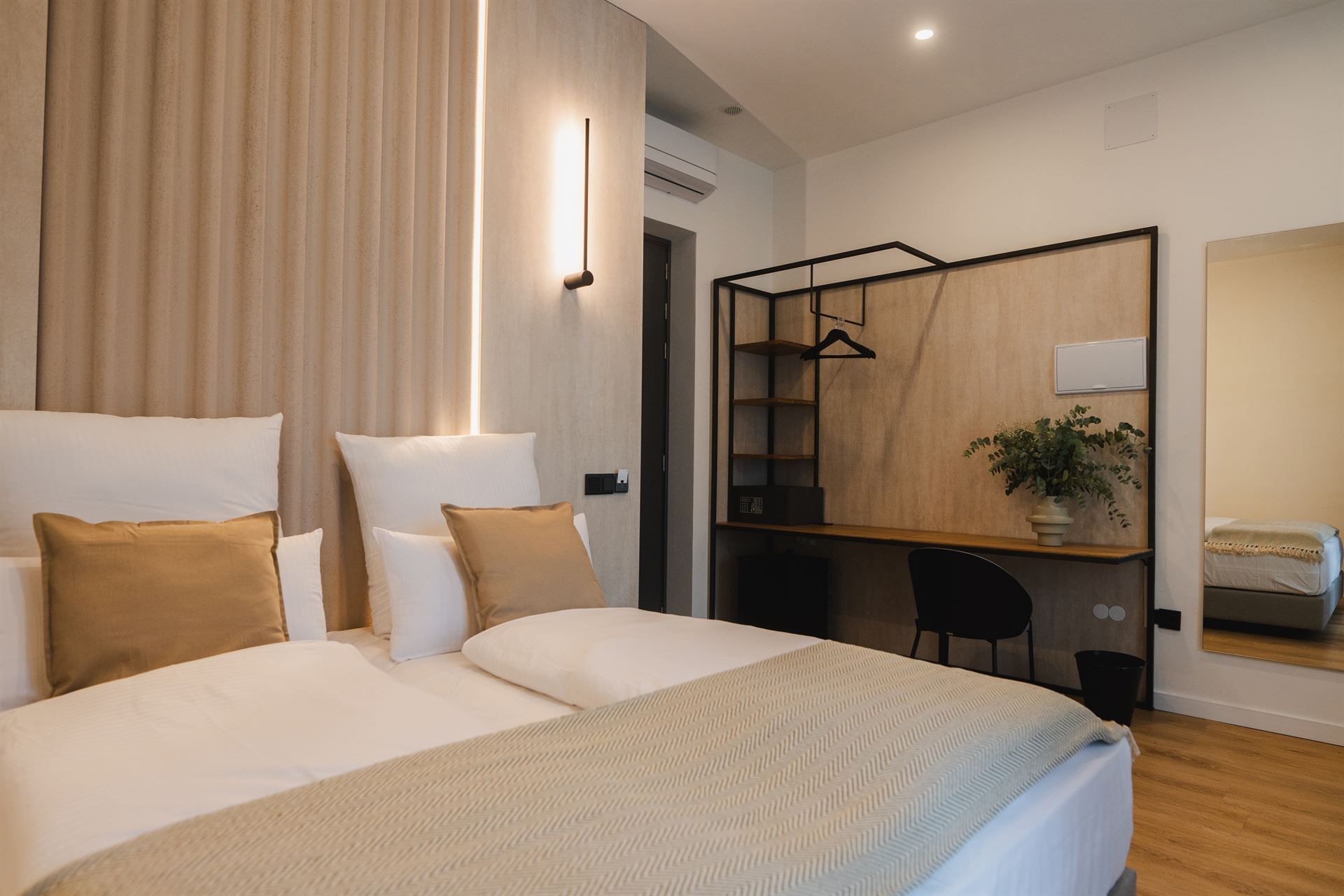 Hotel room interior with bed, lamp, and stylish décor.