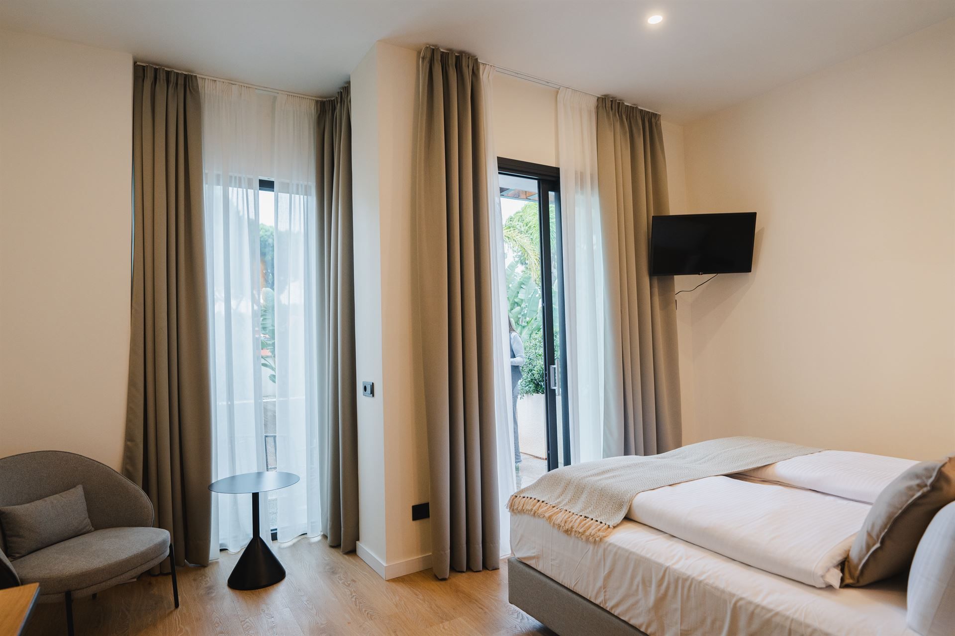 Spacious guest room featuring a neatly made bed and seating area.