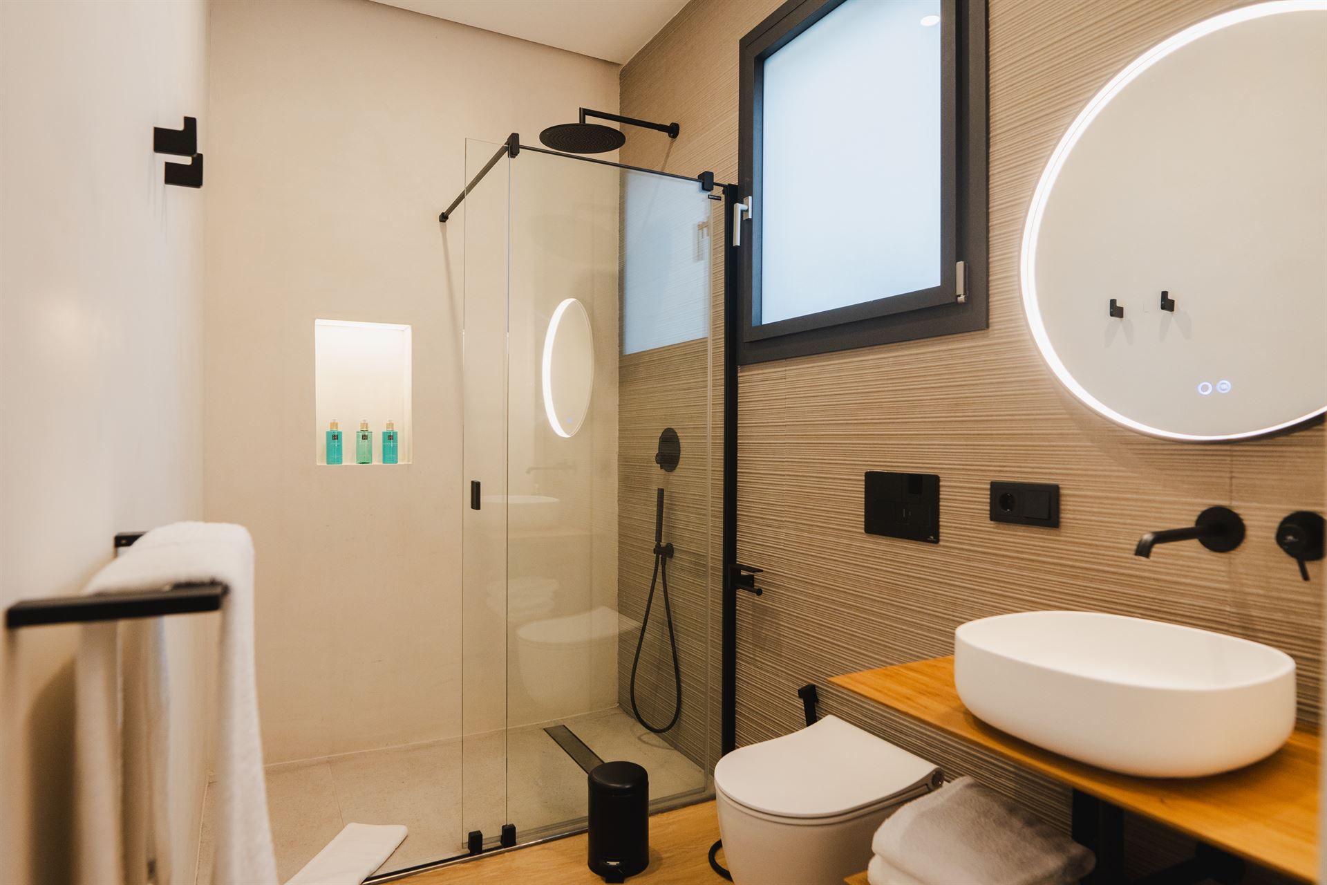 A bathroom with a toilet , sink , shower and mirror.