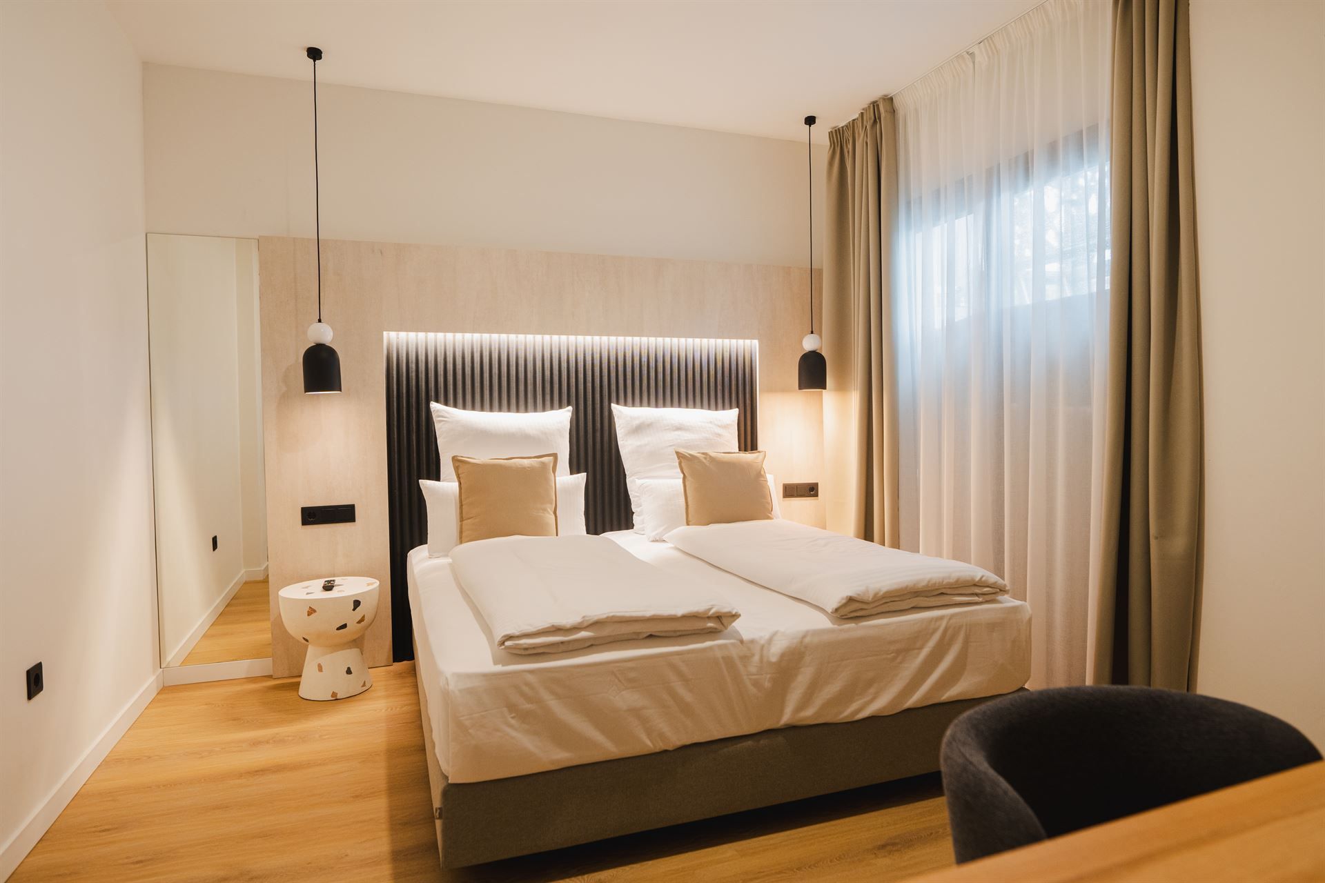 A hotel room with two beds , a desk and a chair.