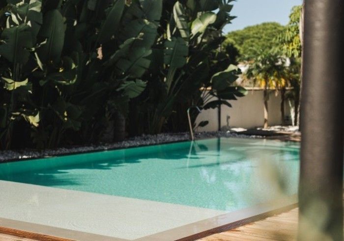 Outdoor swimming pool with clear water and surrounding lounge area.