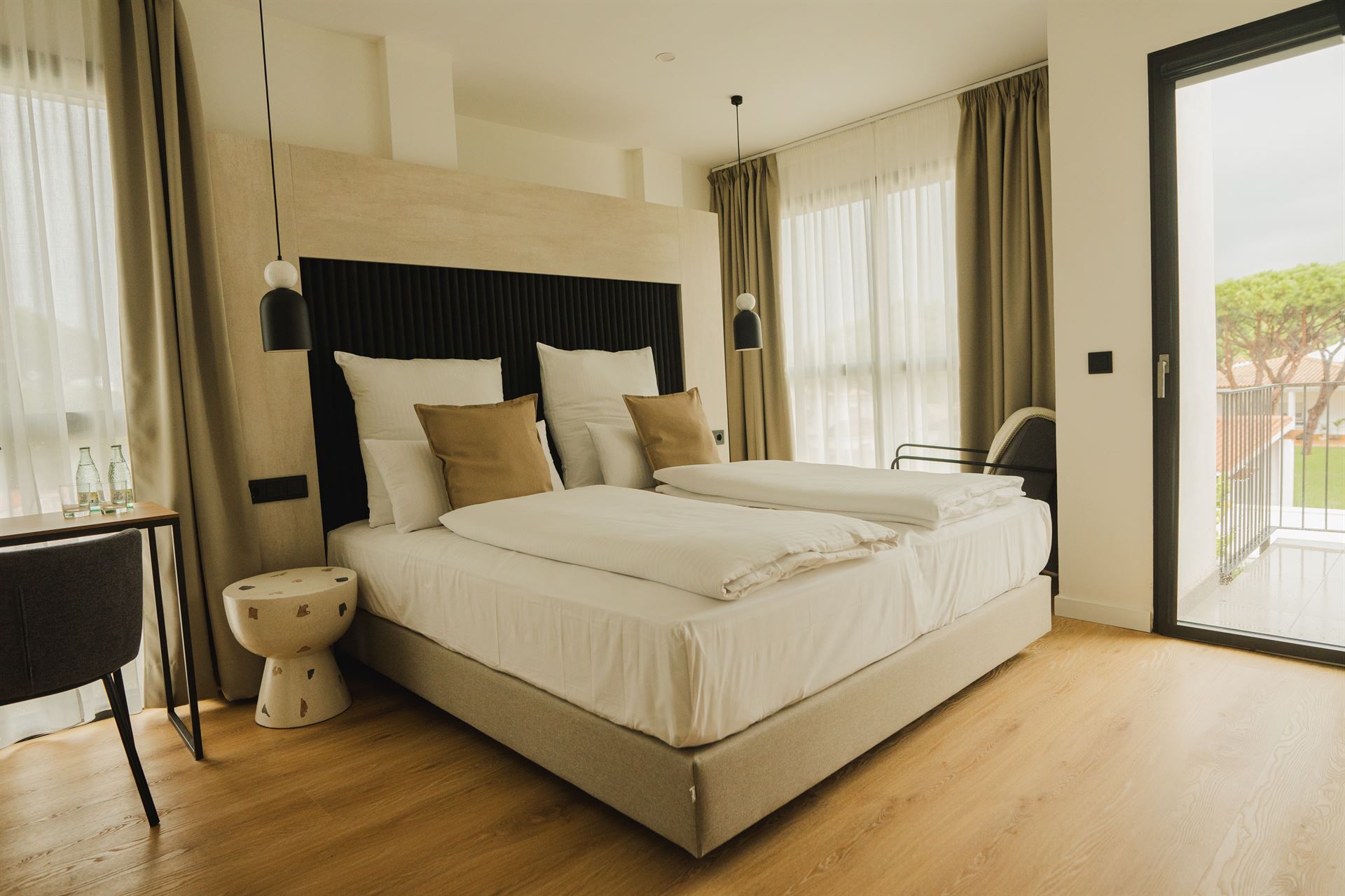 A hotel room with two beds and a sliding glass door