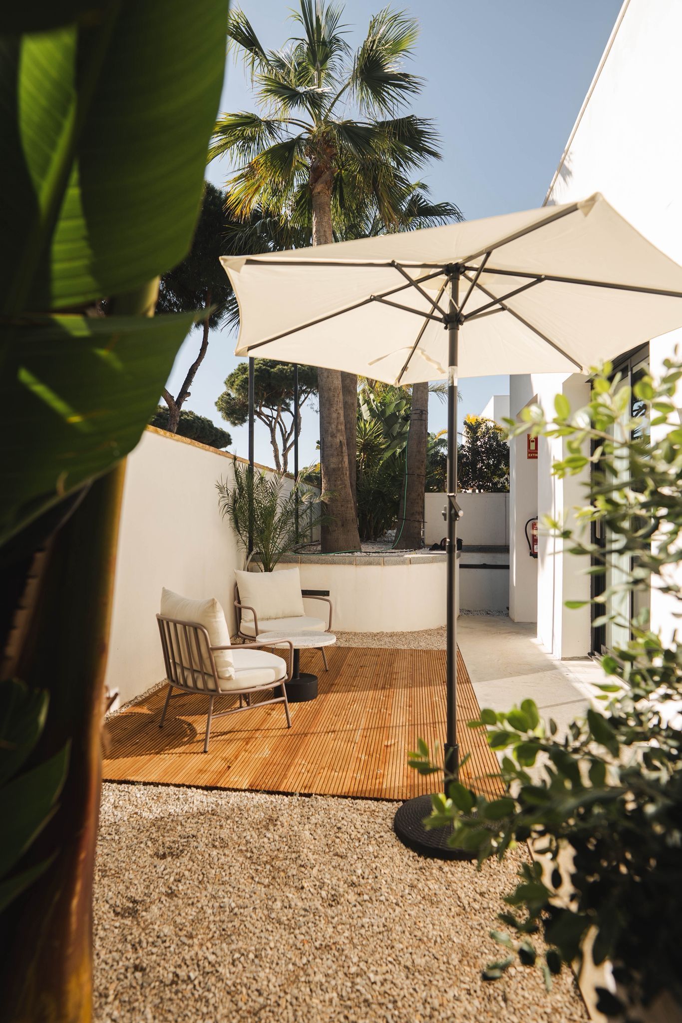 Outdoor pool area with lounge chairs and surrounding greenery.