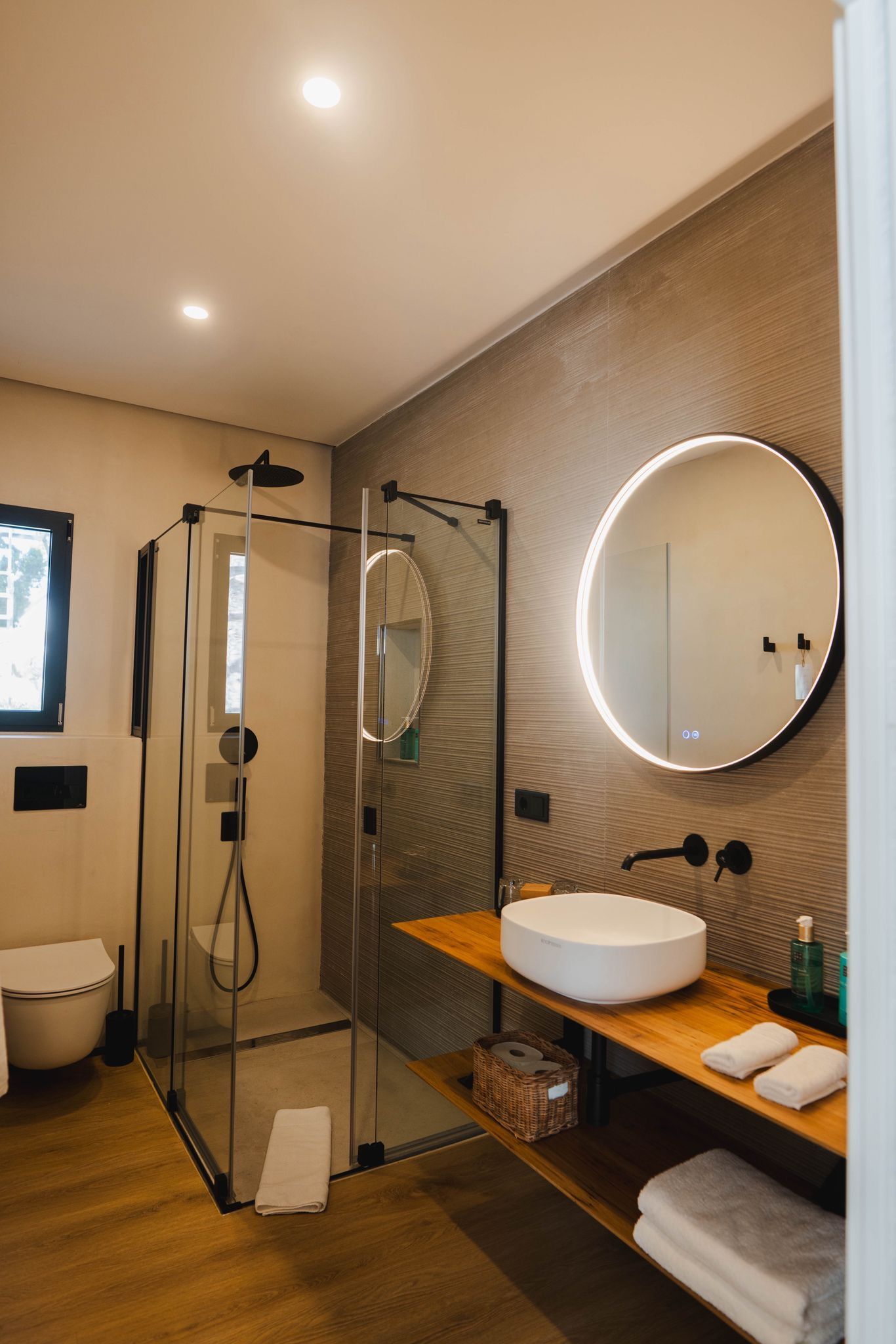 right modern bathroom with ceramic sink, mirror, and glass shower enclosure.