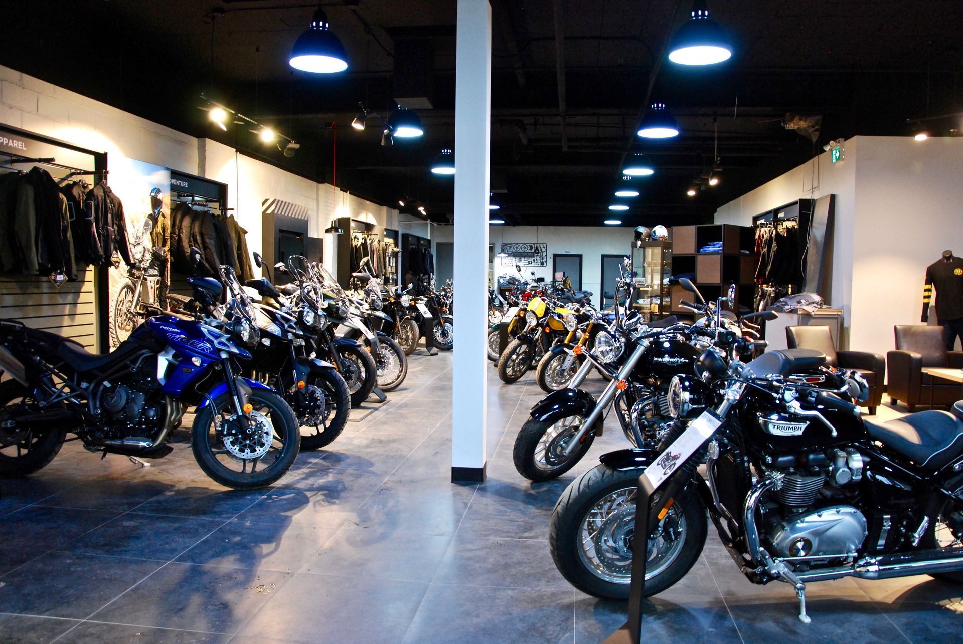 Salle d'exposition de motos présentant différents modèles sous une lumière vive.