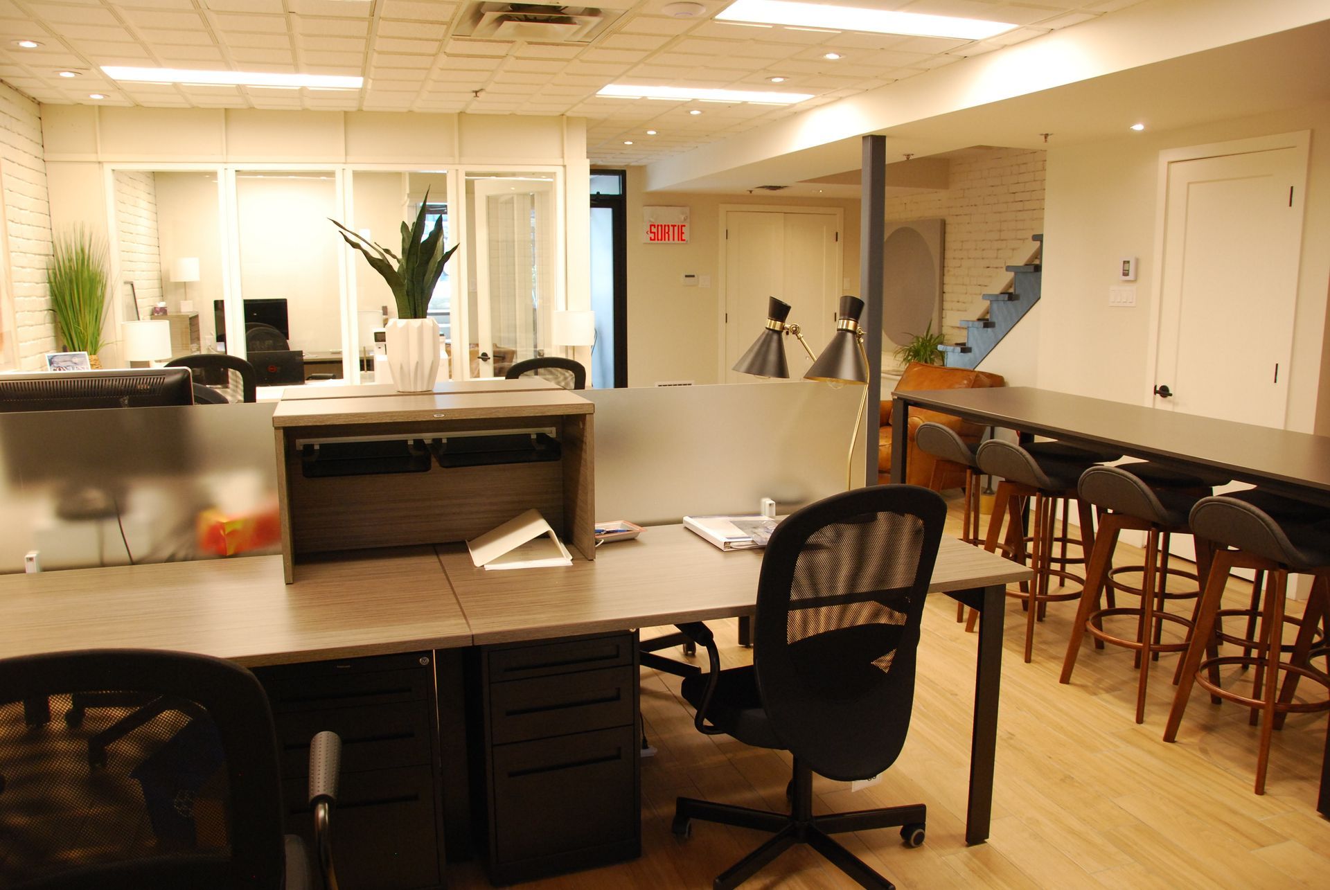 Intérieur de bureau avec bureaux, chaises et une longue table avec tabourets.
