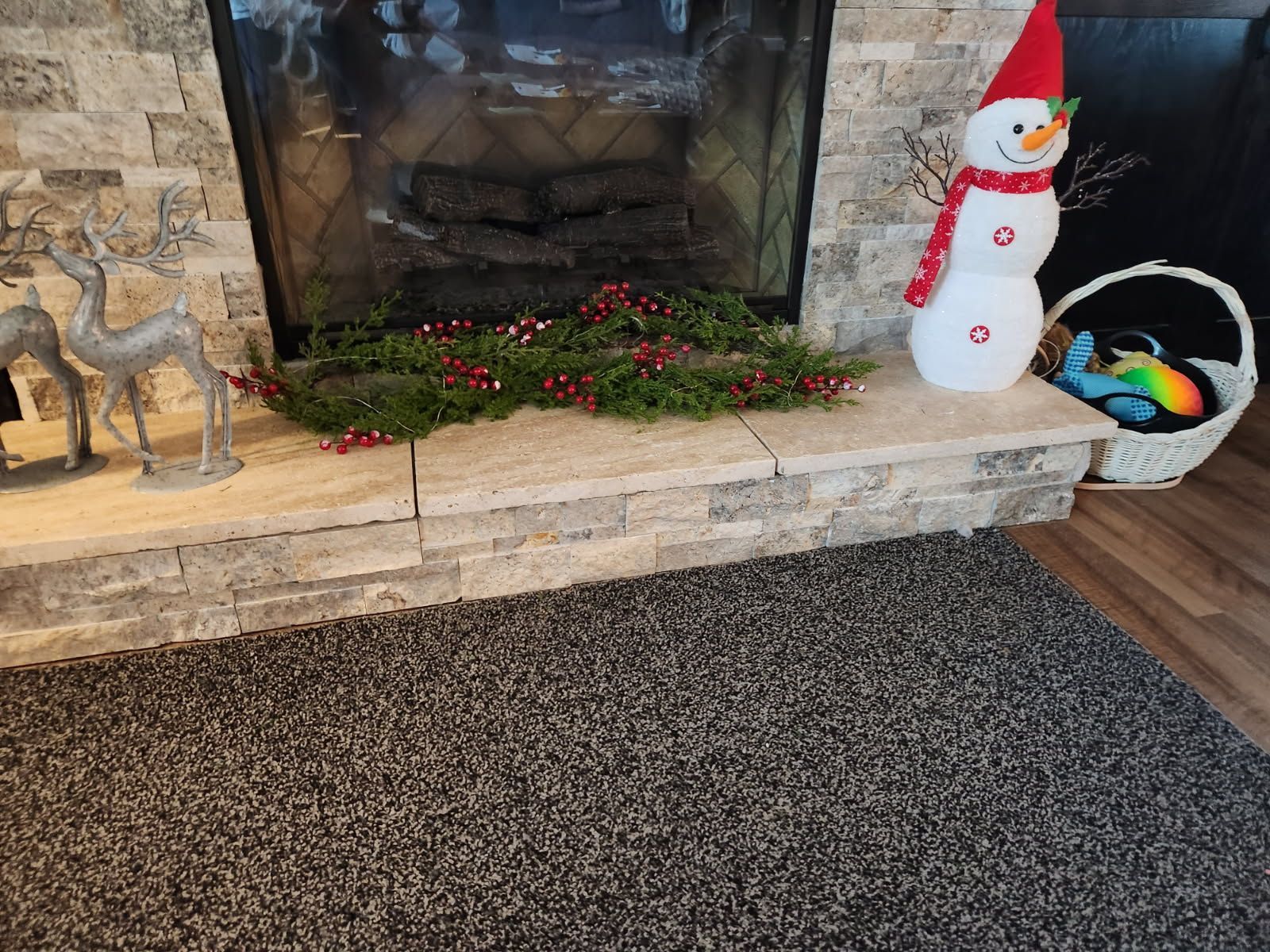 A fireplace decorated for christmas with a snowman and reindeer
