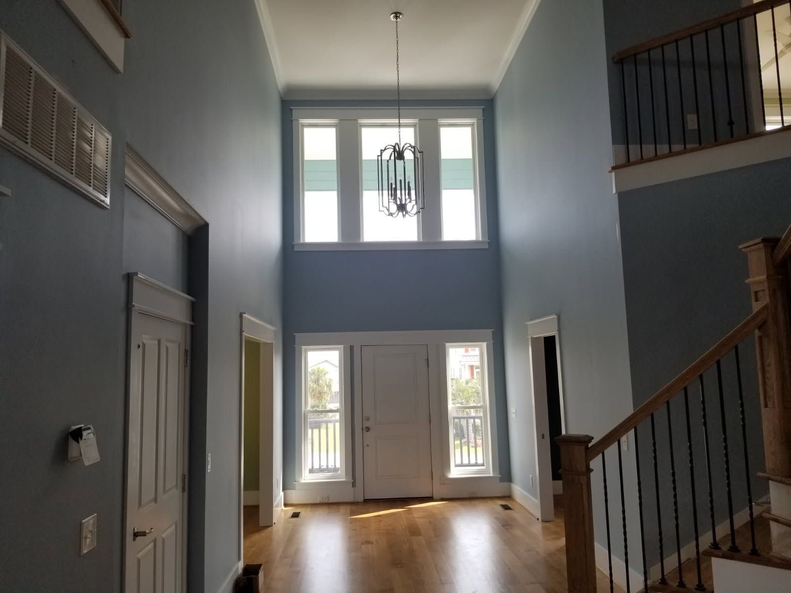 A large empty room with a staircase and lots of windows.
