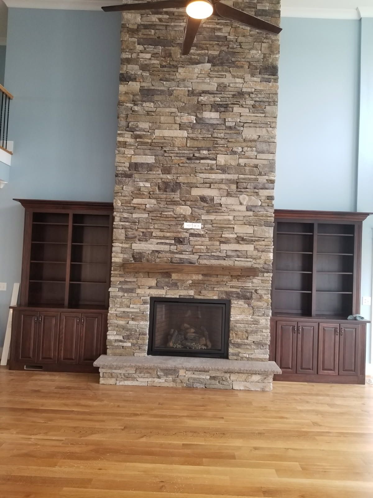 There is a large stone fireplace in the middle of the room.