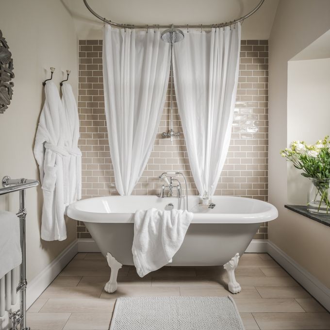 white roll top bath with fresh white towel and white fluffy cotton dressing gowns  | Cotswold Tiger Laundry
