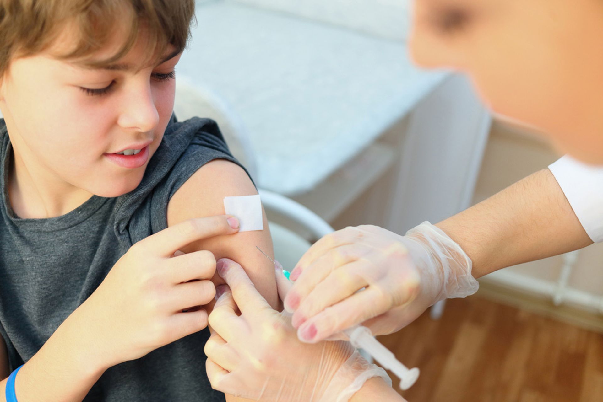 A Young Boy is Getting an Injection in His Arm — Northern Beaches GP Superclinic in Bushland Beach, QLD