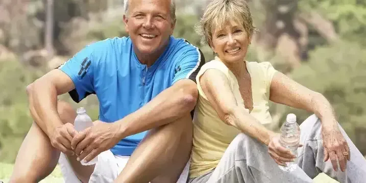 A Man and a Woman Are Sitting Next to Each Other on the Grass — Northern Beaches GP Superclinic in Deeragun, QLD