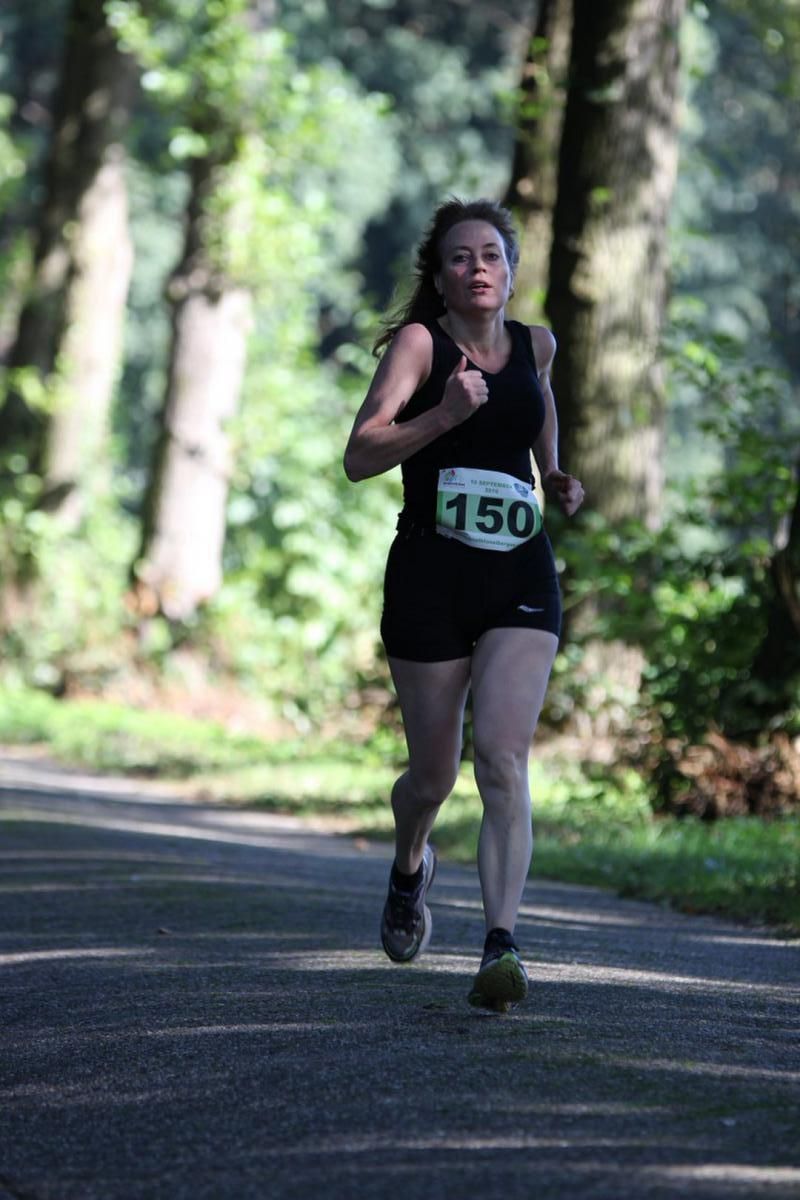 Een vrouw doet mee aan een race met het nummer 150 op haar shirt.