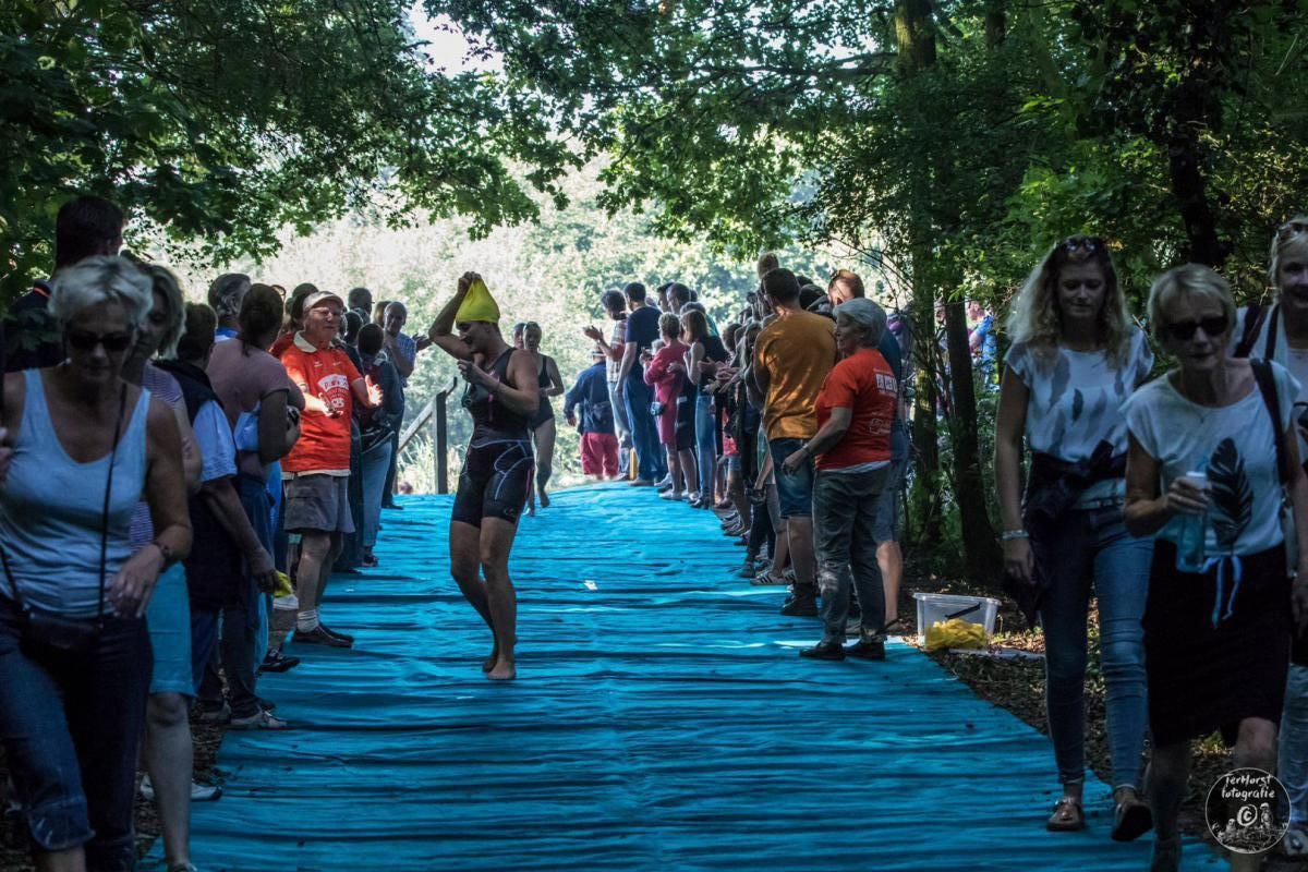 Een groep mensen loopt over een blauwe loper.