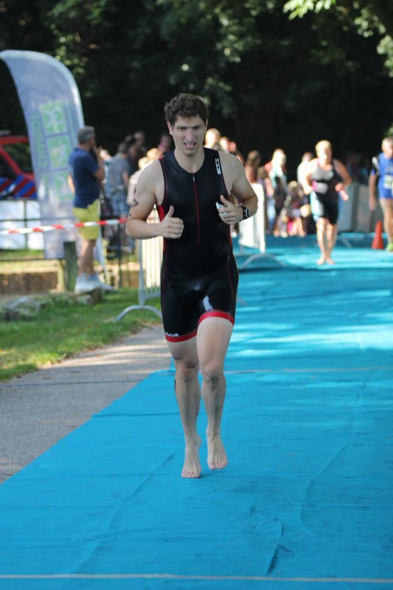 Een man rent op een blauwe mat tijdens een triatlon.