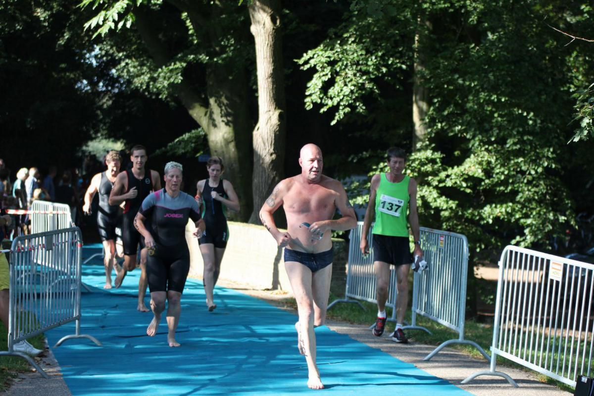 Een man zonder shirt rent in een triatlon