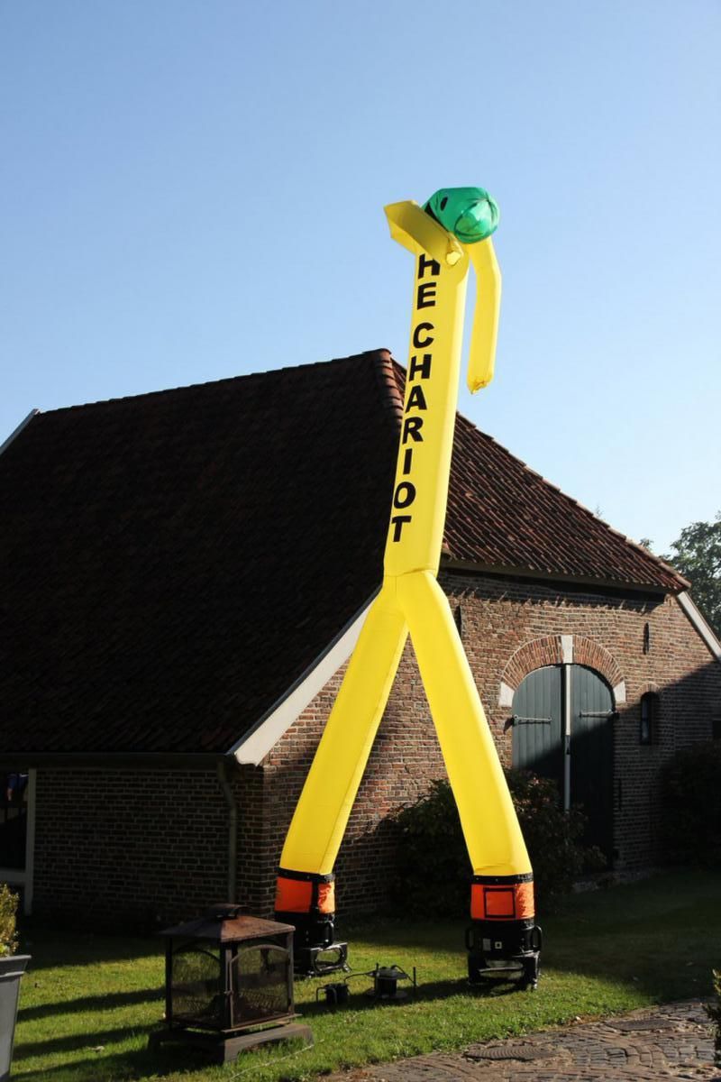 Een gele opblaasbare man met het woord monteur erop