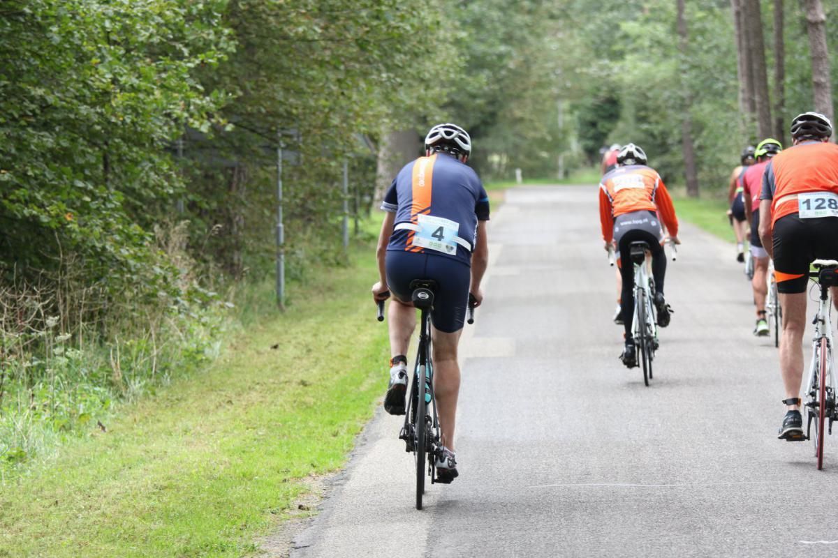 Een groep mensen fietst over een weg.
