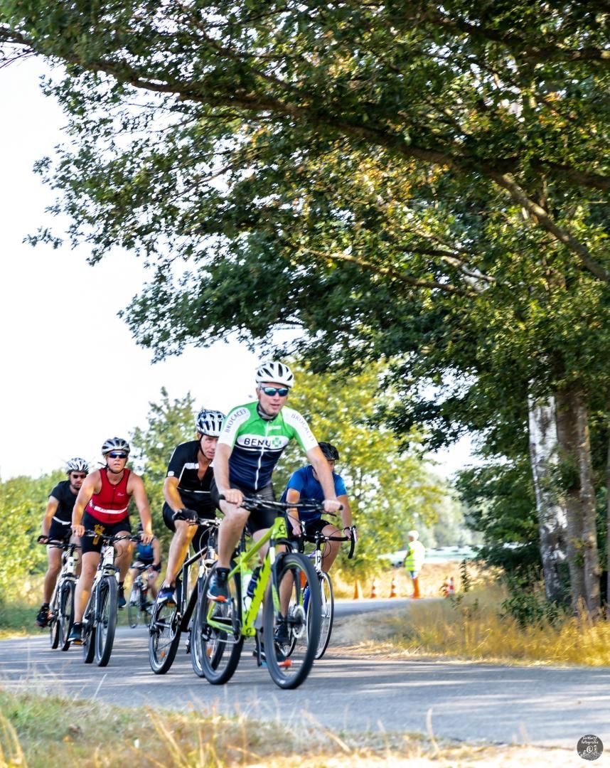 Een groep mensen fietst over een weg.
