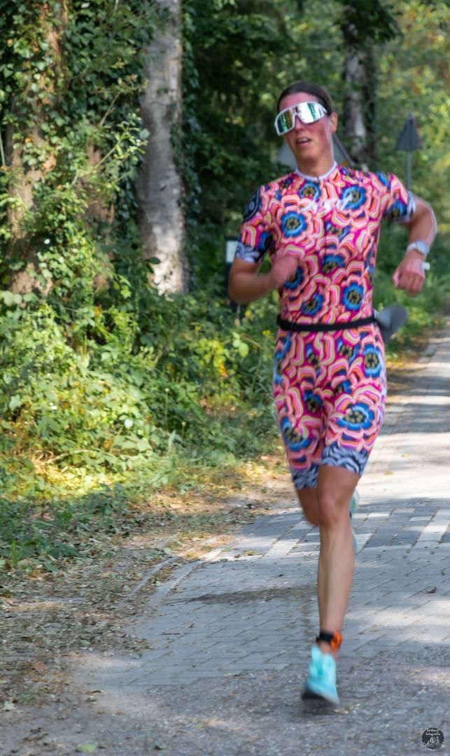Een vrouw in een kleurrijke outfit rent over de weg.