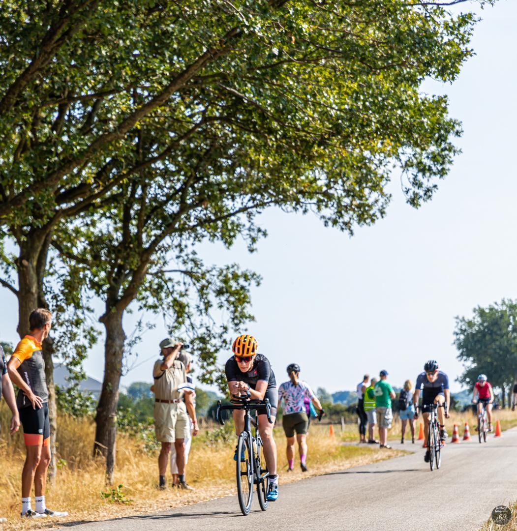 Een groep mensen fietst over een weg.