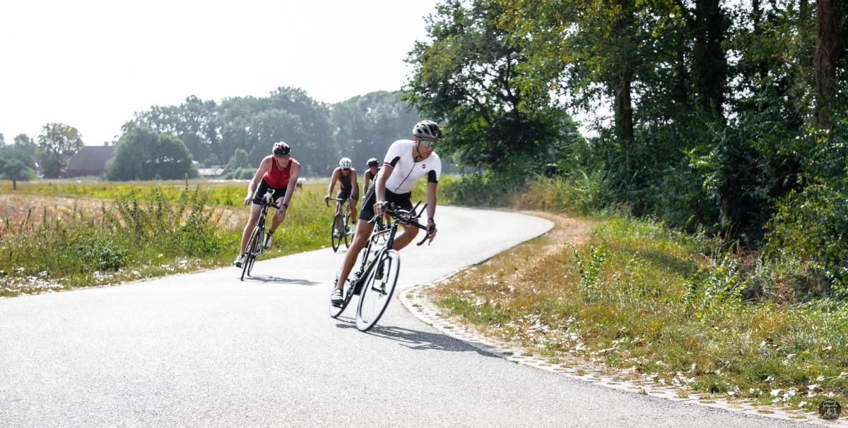 Een groep mensen fietst over een weg.