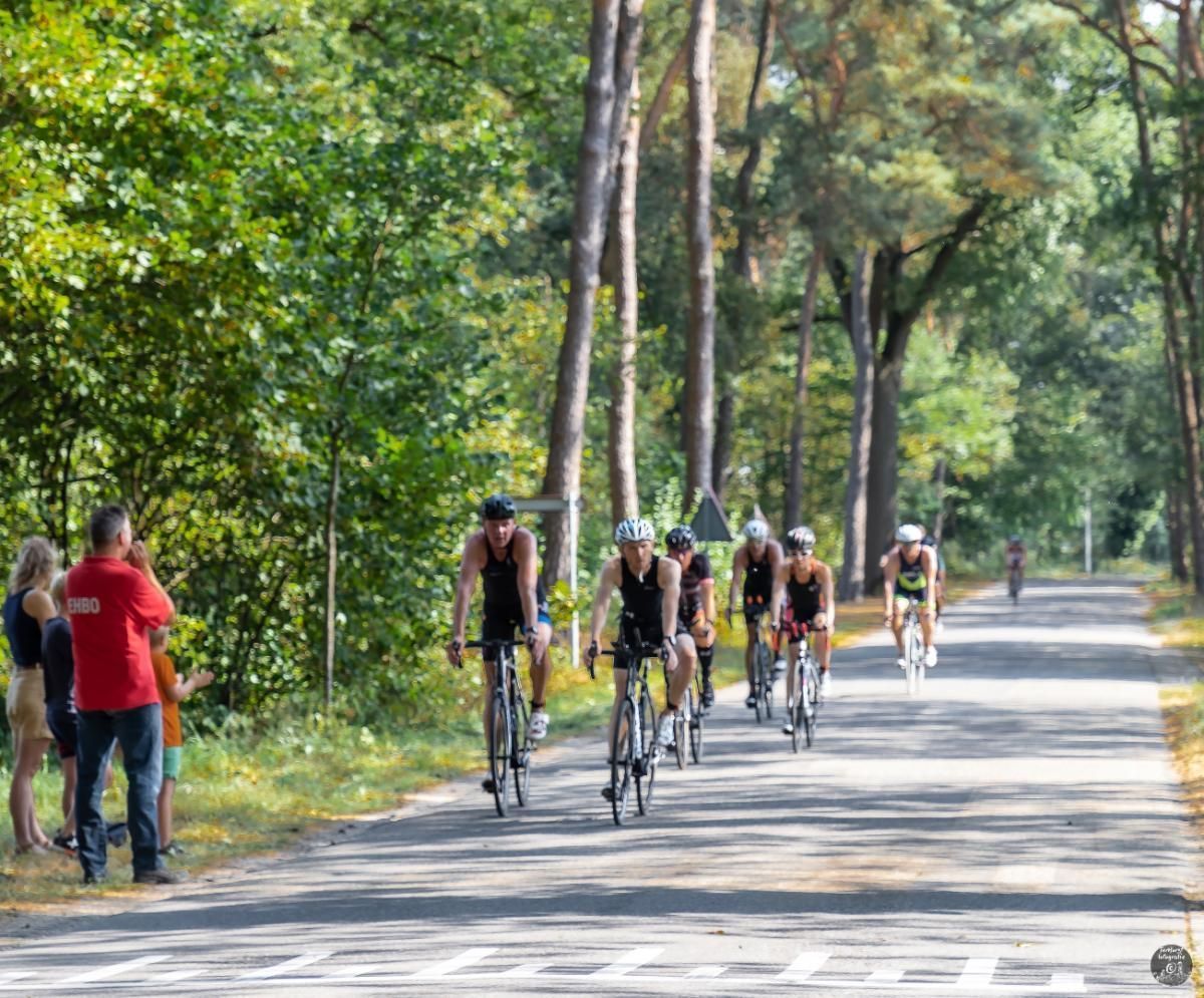 Een groep mensen fietst over een weg.