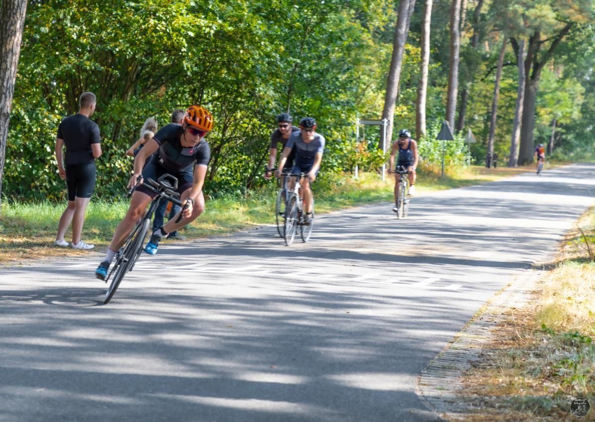 Een groep mensen fietst over een weg.