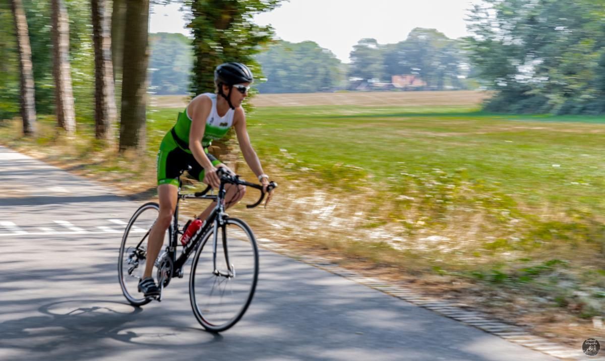 Een vrouw fietst over een landweg.