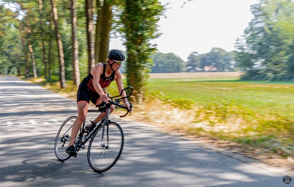 Een vrouw fietst over een weg.