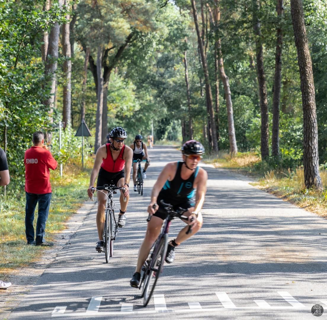 Een groep mensen fietst over een weg