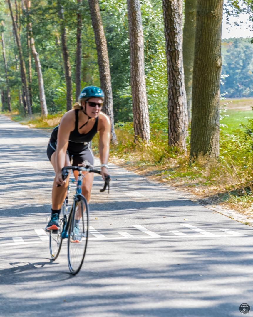 Een vrouw fietst over een weg.