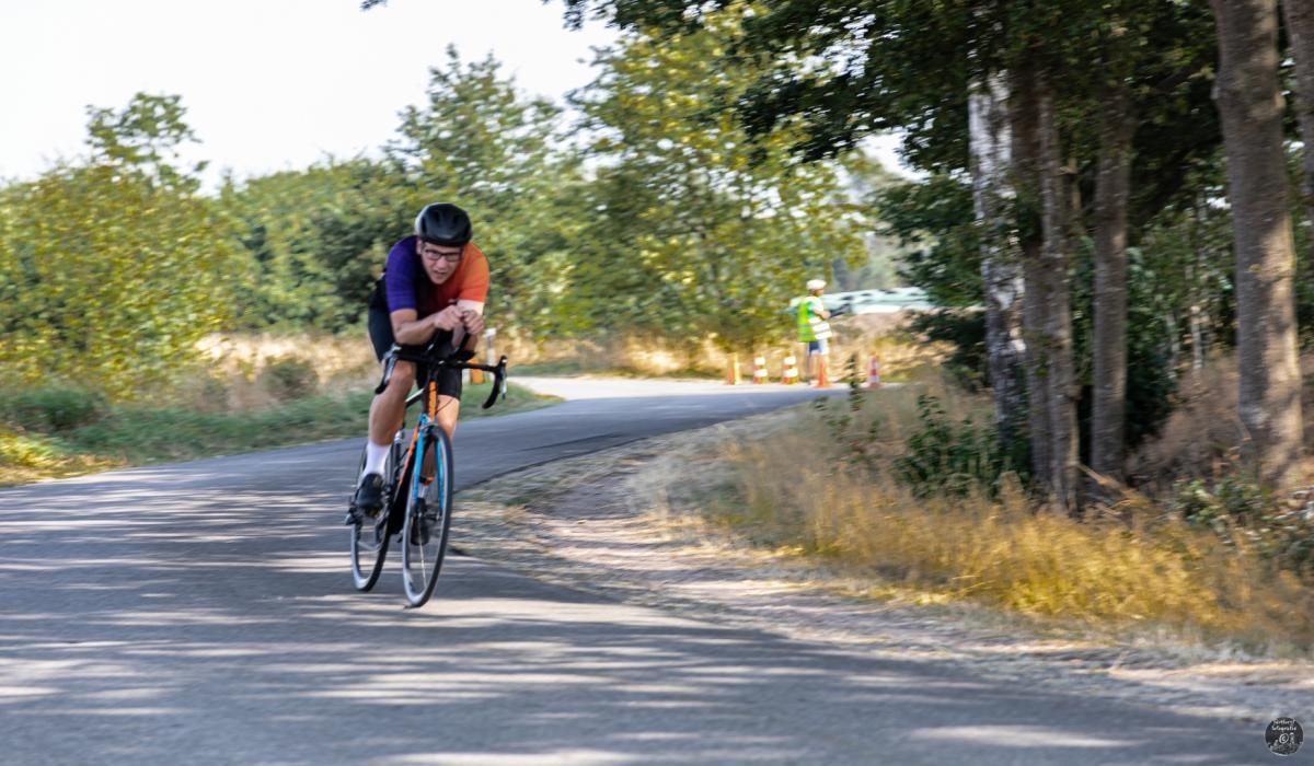 Een man fietst over een landweg.