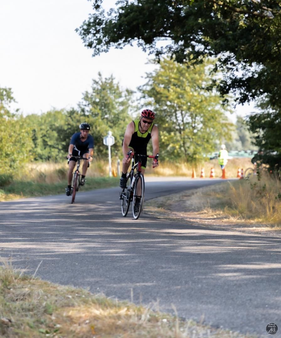 Twee mannen rijden op hun fiets over een weg