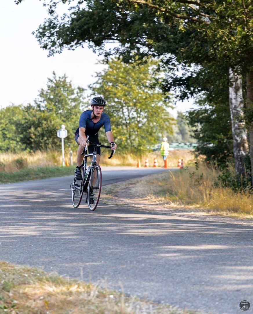 Een man fietst over een landweg.